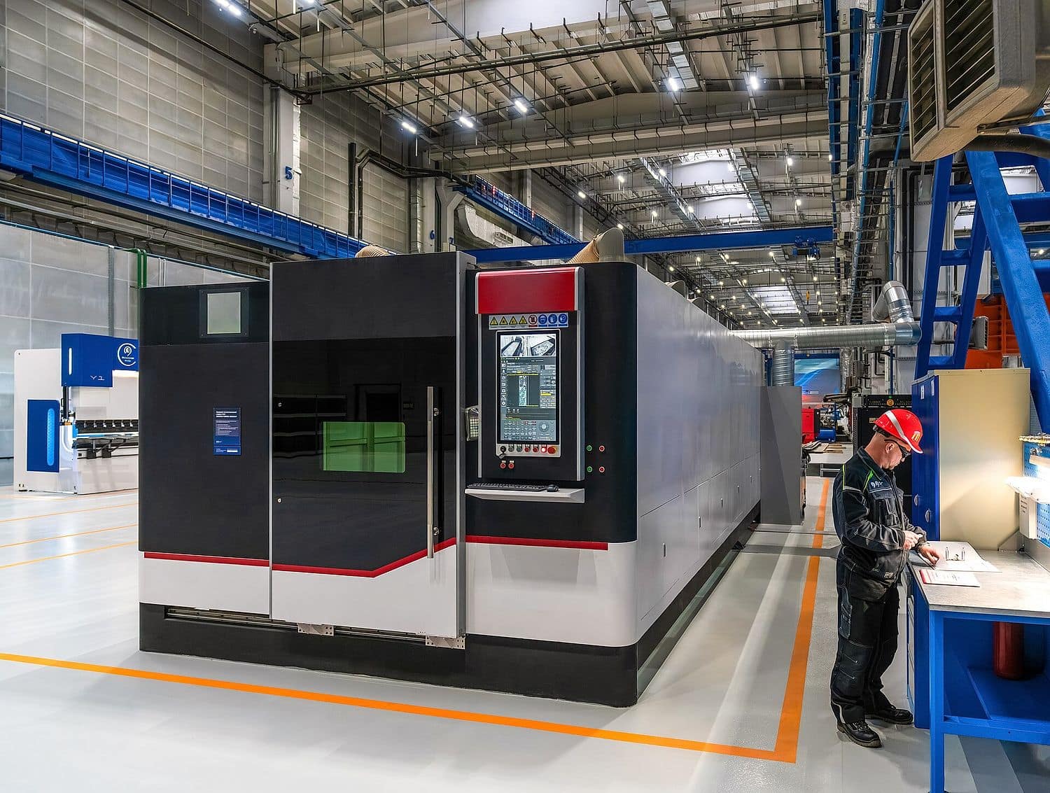 Large-format enclosed fiber laser cutting machine on the SIXPRO production floor